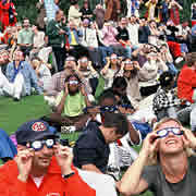 Parc de la Villette - Des visiteurs observent l'éclipse à travers des lunettes protectrices